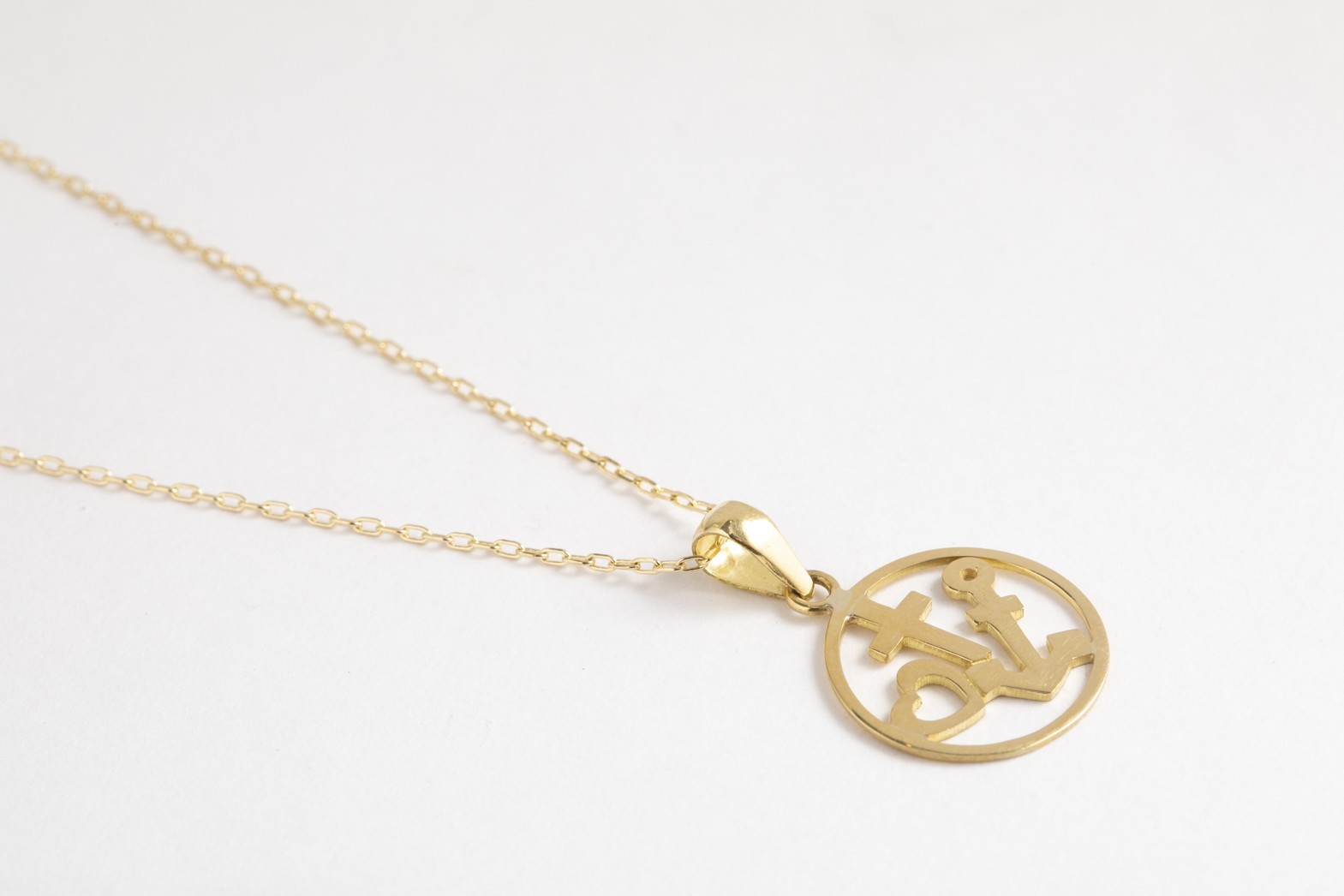 Collar corazón, cruz y ancla en oro amarillo