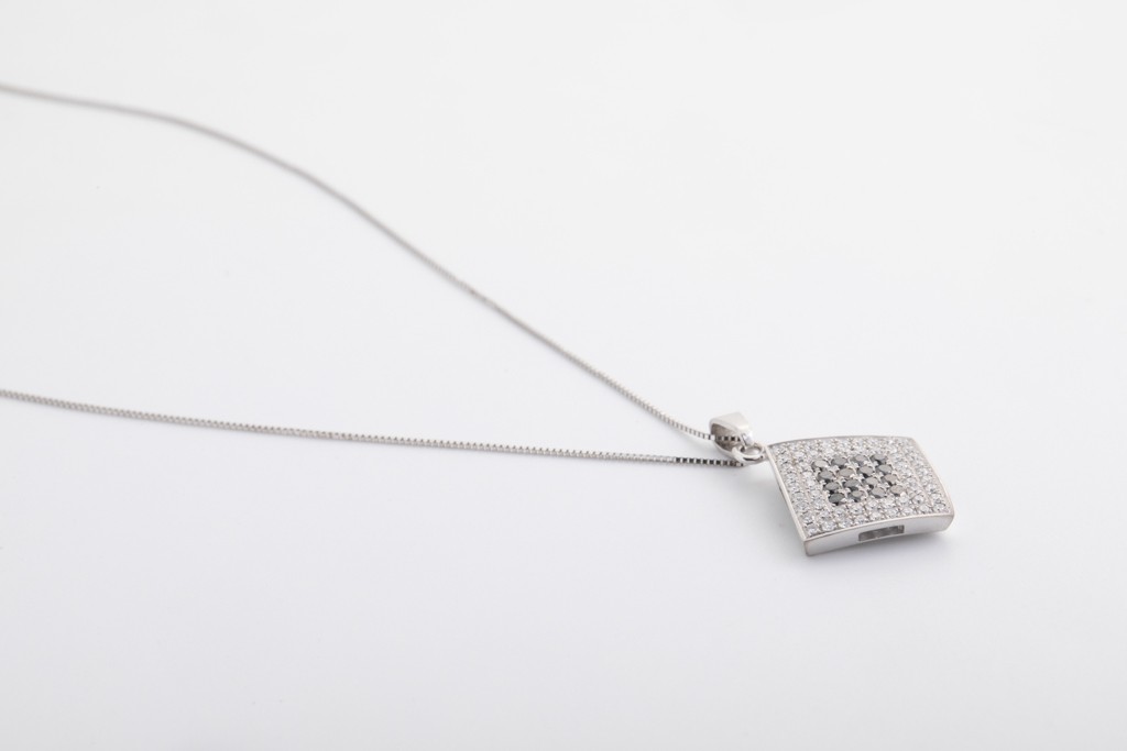 Dije en oro blanco de 18Kt con diamantes blancos y negros